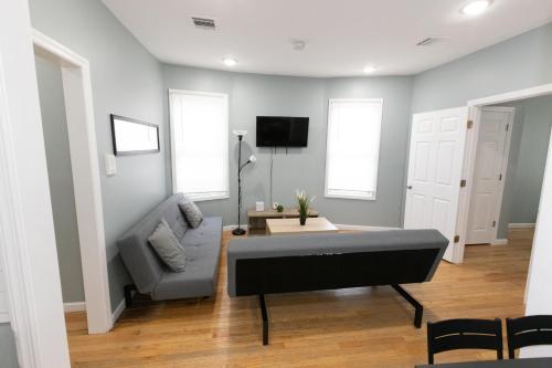 - un salon avec un canapé et une table dans l'établissement Cozy & Classy 3-Bed to mins NYC, à Jersey City
