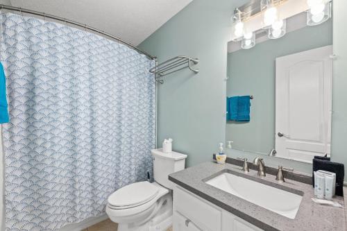 a bathroom with a toilet and a sink and a mirror at 2 BR Home in St Andrews, Close to Everything in Panama City