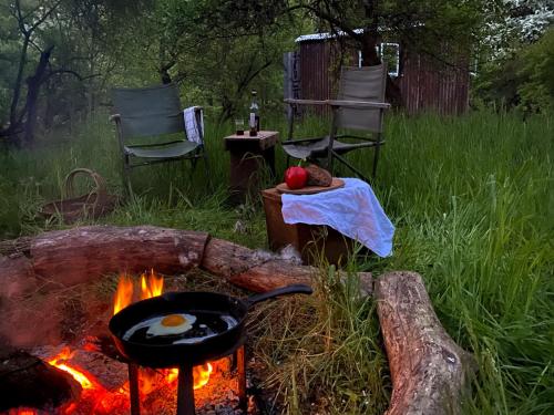 a grill with a pan of eggs on top of a fire at The shepherds hut at abberley glamping in Abberley