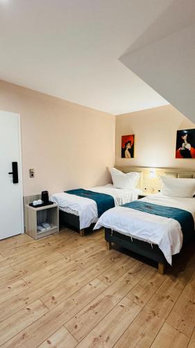 2 camas en una habitación con suelo de madera en Hotel Libers, en Lauterbach