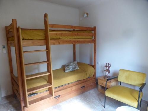 un letto a castello con una scala e una sedia in una stanza di 2 chambres au calme Villa Chrisma Provence a Orgon