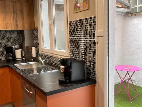 uma cozinha com um lavatório e uma bancada em Le Refuge d'Omer em Saint-Omer