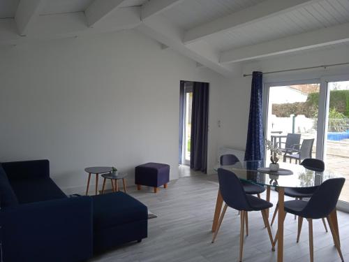 - un salon avec une table et des chaises en verre dans l'établissement Villa du lagon avec piscine, à Saint-Michel-en-lʼHerm
