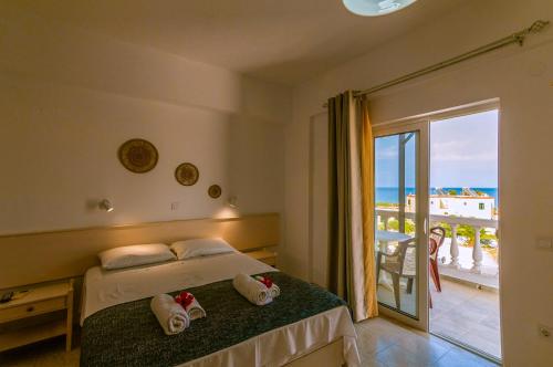 a bedroom with a bed and a view of the ocean at Irene Apartments in Karpathos