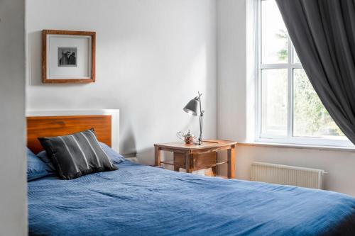 a bedroom with a blue bed and a window at 2 Bedrooms near Central London in London