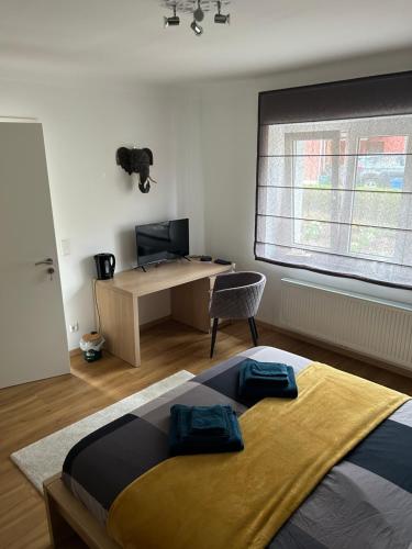 a bedroom with a bed and a desk and a window at Le cocon de Céline in Eischen