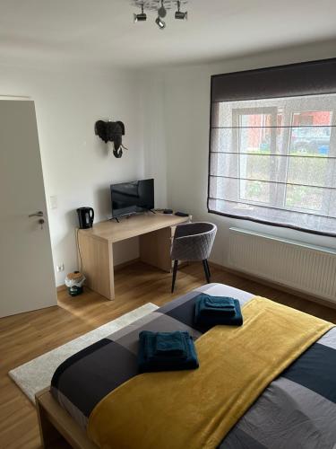 1 dormitorio con cama, escritorio y ventana en Le cocon de Céline, en Eischen