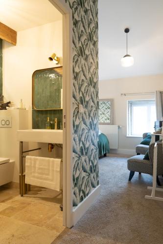 La salle de bains est pourvue d'un miroir et d'un lavabo. dans l'établissement L'ACADEMIE, à Leynes