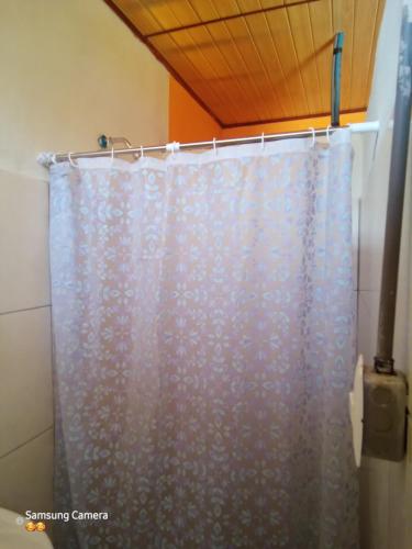 - Baño con cortina de ducha azul en Cocibolca House B&B, en Altagracia