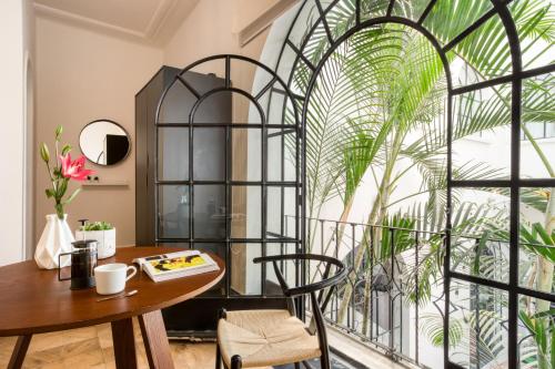 a room with a table and chairs and a large window at Santa Casa by Tasman in Mexico City