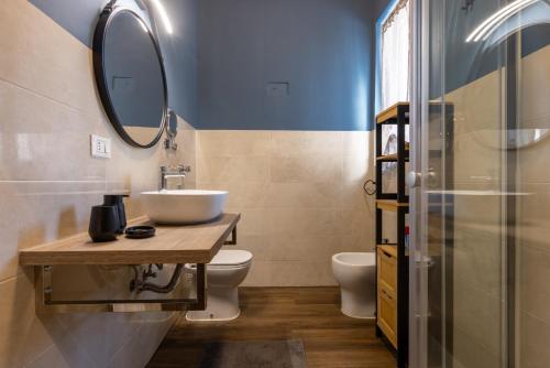 a bathroom with a sink and a toilet and a mirror at Volta 8 Apartments in Rho