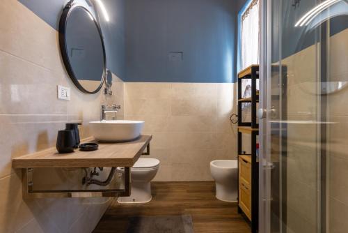 un bagno con lavandino, water e specchio di Comfort Home Rho Fiera a Rho