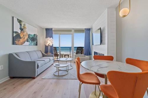 a living room with a couch and a table with chairs at Tranquil Palms-Oceanfront Condo in Myrtle Beach