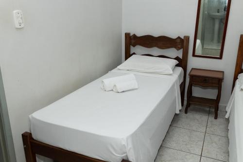 a bedroom with a white bed and a mirror at Carlton Express Imbiara in Araxá