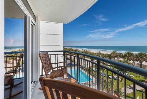 a balcony with two chairs and a view of the ocean at Tranquil Palms-Oceanfront Condo in Myrtle Beach