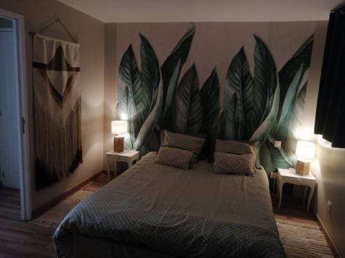 a bedroom with a bed with a large mural on the wall at La maison de 6Fran appartement 2 chaleureux et calme ambiance familiale in Valros