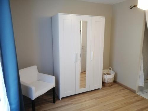 a white closet with a chair and a mirror at La maison de 6Fran appartement 2 chaleureux et calme ambiance familiale in Valros