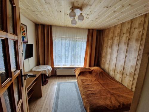 a bedroom with a bed and a window in a room at Pokój pod lasem u Ewki in Zakopane