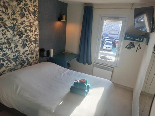 Una habitación de hotel con una cama con una bolsa azul. en Fasthotel, en Jaux