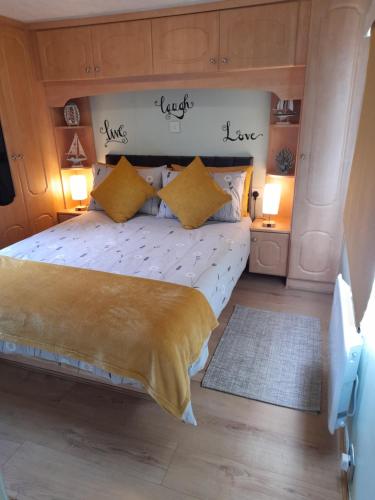 a bedroom with a large bed with yellow pillows at Gilfach in Clynnog-fawr