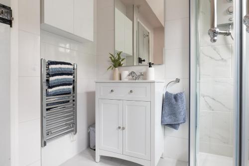 Un baño blanco con lavabo y ducha. en Remarkable Cotswolds 1 bedroom cottage in Finstock, en Finstock