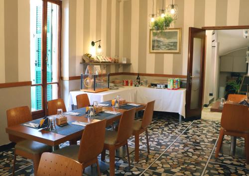 a restaurant with two tables and chairs and a counter at Hotel Lora in Bordighera