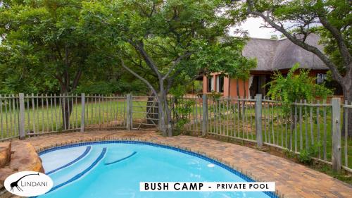 a fence around a small blue swimming pool in front of a house at Lindani Game and Lodges in Vaalwater