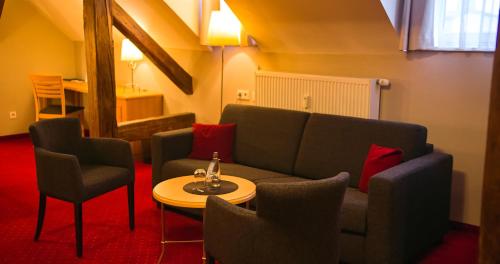 a living room with a couch and chairs and a table at Hotel Vollmann in Weilheim in Oberbayern