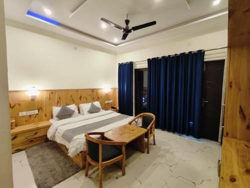 a bedroom with a bed and a table and chairs at maharaja resort in Candolim