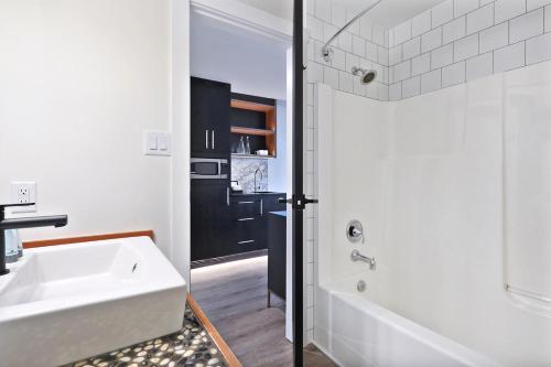 y baño con bañera blanca y lavamanos. en Kingfisher Pacific Resort & Spa, en Courtenay