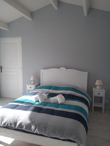 une chambre avec un lit avec deux serviettes dessus dans l'établissement Villa du lagon avec piscine, à Saint-Michel-en-lʼHerm