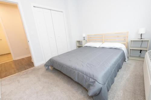 a bedroom with a bed in a white room at Modern & Cozy 2 - Bedroom gem mins from NYC in Jersey City