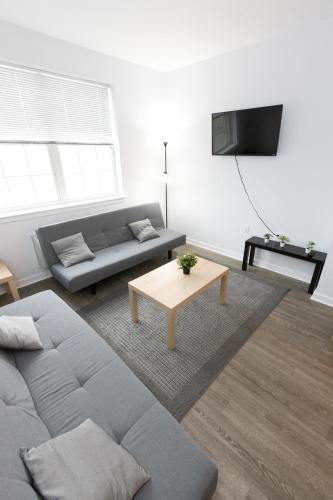 uma sala de estar com um sofá e uma mesa em Modern & Cozy 2 - Bedroom gem mins from NYC em Jersey City