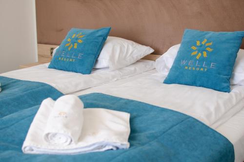 2 camas con almohadas azules y toallas. en Apartament 106 Mari - Welle, en Grzybowo