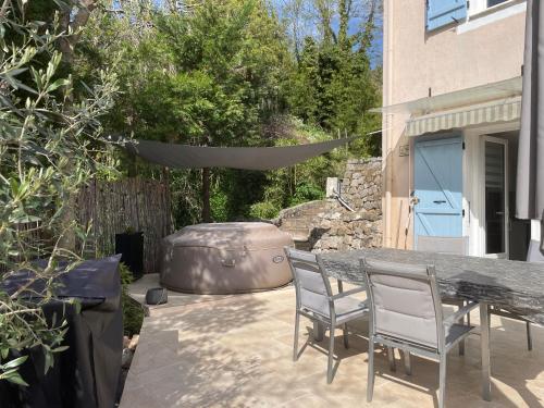 a patio with a table and chairs and a grill at LUVA d'Azur, Rez de villa LE RIOU - LE VALLON in Le Bar-sur-Loup