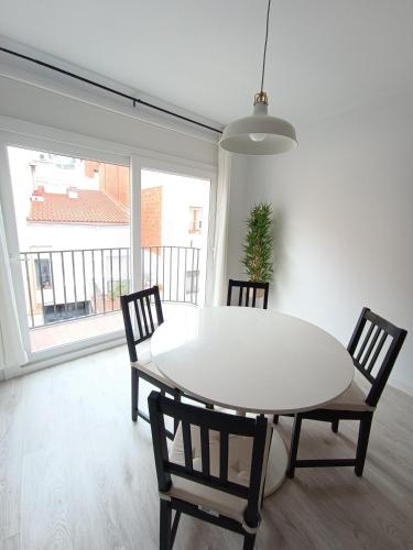 a dining room with a white table and chairs at Aiguaneu S'Auguer in Blanes