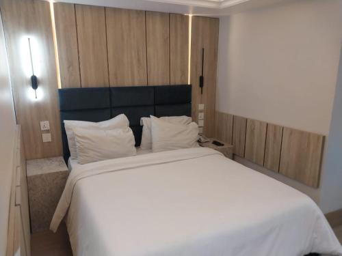 a bedroom with a large bed with white sheets and pillows at C. Apartments Annex in Abuja