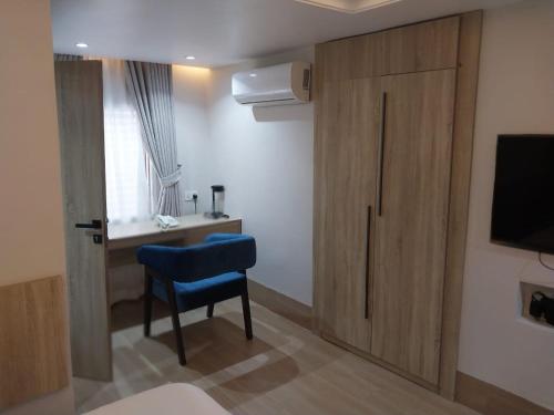 a room with a door and a chair and a desk at C. Apartments Annex in Abuja