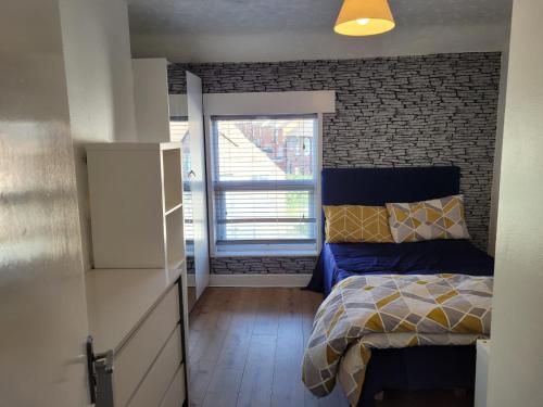 a bedroom with a bed and a brick wall at Nice single bedroom near QMC in Nottingham
