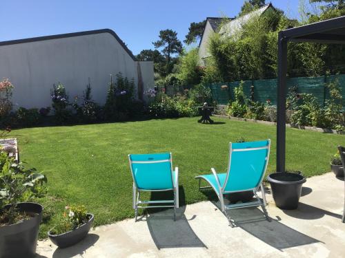 zwei blaue Stühle in einem Garten mit Rasen in der Unterkunft Apt 2 3 personnes acces jardin 15 min de la mer in Brech