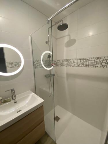 een badkamer met een glazen douche en een wastafel bij Charmant appartement in Argelès-Gazost