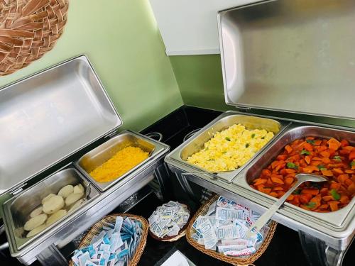 Pousada Jardins Tropical في بورتو دي غالينهاس: ثلاجة مليئة بالأصواني ذات الأنواع المختلفة من الطعام