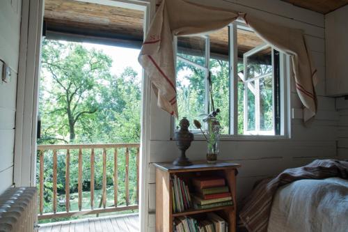 1 dormitorio con ventana, cama y balcón en The cabin at Abberley Glamping, en Abberley
