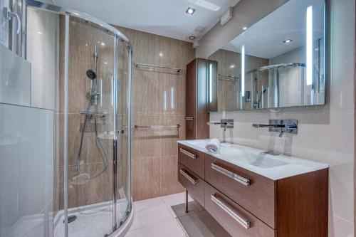 y baño con ducha y lavamanos. en La Villa - Piscine / Karaoké / Jeux en Fontaine