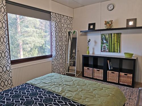 a bedroom with a bed and a large window at Boho Apart Ututie in Kotka