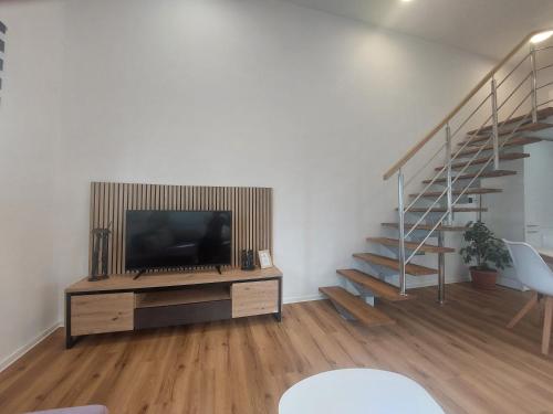 a living room with a tv and a staircase at SPRING and SUMMER apartment near Ljubljana with FREE secure parking in Domžale