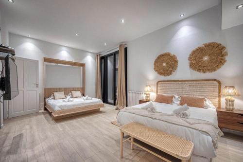 ein großes Schlafzimmer mit 2 Betten und 2 Tischen in der Unterkunft La Villa - Piscine / Karaoké / Jeux in Fontaine