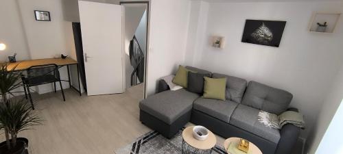 ein Wohnzimmer mit einem grauen Sofa und einem Tisch in der Unterkunft "Modern Cosy" Bernay hyper centre in Bernay