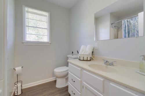 a white bathroom with a toilet and a sink at The Old Parsonage Pindall House with Patio! 