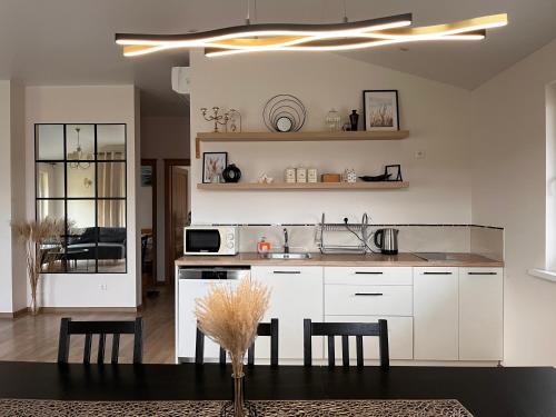 a kitchen with white cabinets and a table and chairs at Vila Trakai in Trakai